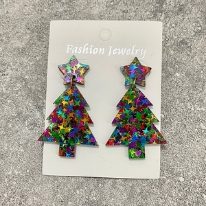 Detail der Weihnachtsbaum-Ohrringe mit bunten Glitzersternen auf Acrylmaterial