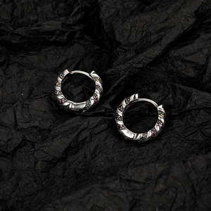Pair of vintage silver hoop earrings with rainbow cubic zirconia on black paper