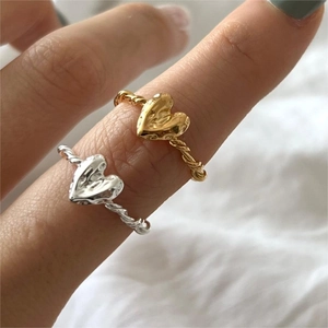 Hand wearing 925 silver irregular heart hammered rings in gold and silver finish