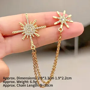 Detailansicht goldener Sternen-Broschen mit glitzernden Kristallen und doppelter Kette