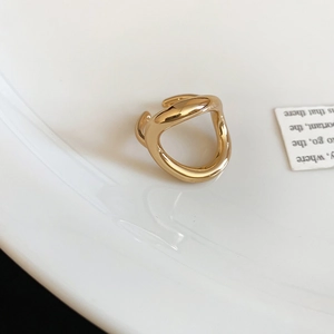 Macro shot of minimalist gold geometric open ring with polished liquid metal finish