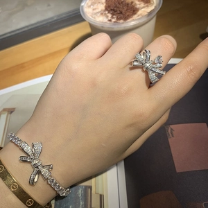 Détail de l'ensemble bracelet et bague nœud argenté avec zircons sur modèle
