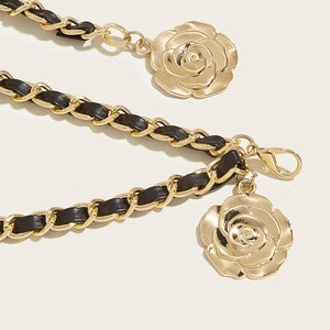 Vue macro de la chaîne dorée tressée avec cuir noir et pendentif rose élégant