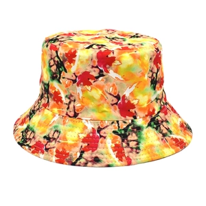 Detailed close-up of maple leaf print on a vibrant tie-dye reversible bucket hat