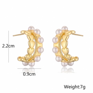 Detalle de pendientes de corazón en forma de C bañados en oro 18K con perlas