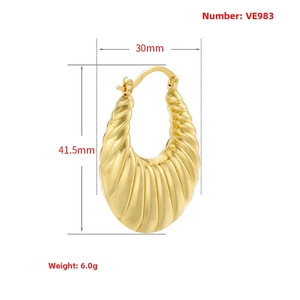 Detailed macro view of gold-plated hollow hoop earring with ribbed vintage texture
