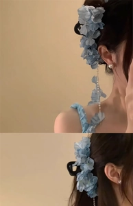 Detailopname van lichtblauwe stoffen bloemen haarklem met elegante parel franjes