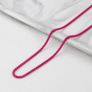 Macro shot of vibrant rose red enamel box chain necklace with modern stainless steel plating