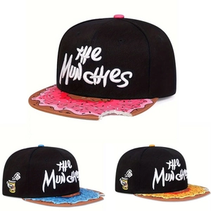 Detail of flat brim snapback hat showing donut frosting embroidery and realistic bite mark