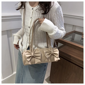 Détail du sac polochon beige avec doubles nœuds géants et bandoulière en cuir souple