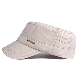 Detail of beige cotton flat top military cap showing metal plate and decorative stitching