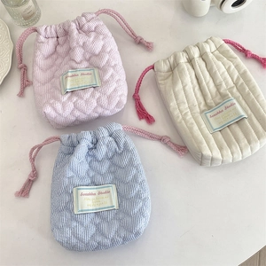 Dettaglio di sacchetti trapuntati con coulisse in rosa, blu e bianco con cuori