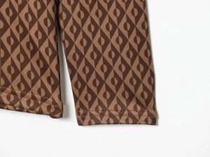 Détail de haut thermique de ski avec motifs géométriques marron sur les poignets