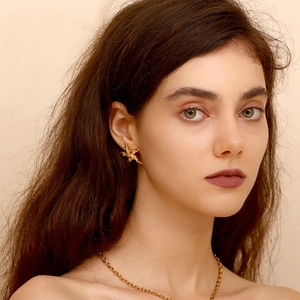 Close-up of 18K gold plated starfish stud earring and matching necklace on a model