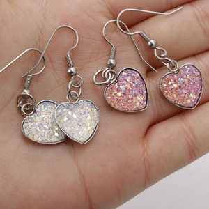 Sparkly heart-shaped earrings with glittering sequins in white and pink color options