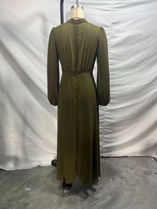 Detail view of the army green chiffon dress featuring a stand collar and pleated maxi hem