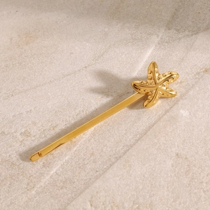Detailansicht einer goldenen Seestern-Haarklammer mit feiner geprägter Metallstruktur