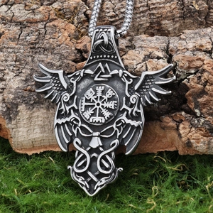 Detail of Viking compass and Valknut symbols on an antique silver pendant in nature