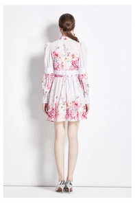 Détail de la robe courte fleurie blanche avec manches bouffantes et imprimés roses
