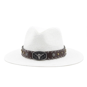 Close-up of western straw hat with vintage metal bull head and leather decorative band
