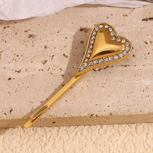 Detail of 18K gold-plated heart-shaped hair clip with sparkling rhinestones and metal finish