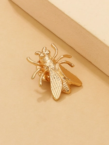 Detailed close-up of a golden insect brooch with intricate wing textures and artistic metal finish