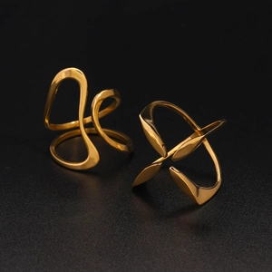 Close-up of dual minimalist golden stainless steel rings with abstract geometric lines