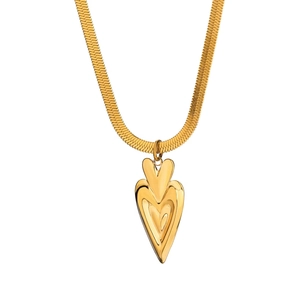Dettaglio della collana con pendente a cuore d'oro e catena a serpente piatta su bianco