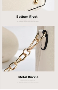 Detail view of cream textured leather bag with protective bottom studs and gold chain hardware