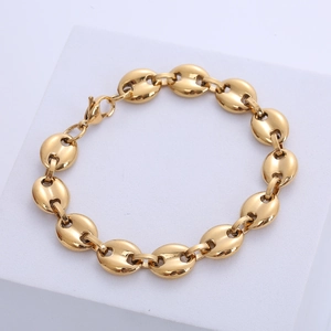 Detail shot of golden coffee bean link chain bracelet with lobster clasp on geometric stand