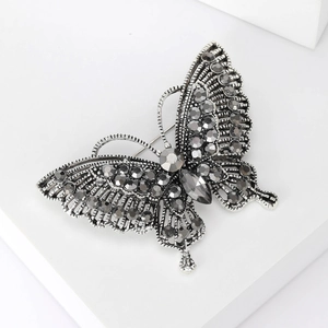 Detailed macro of vintage silver butterfly brooch with grey rhinestones and hollow mesh wings