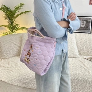 Detail of lavender quilted tote bag with cute cartoon dog embroidery and checkered handles