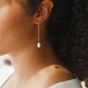 Boucles d'oreilles élégantes en chaîne dorée avec perles baroques sur mannequin