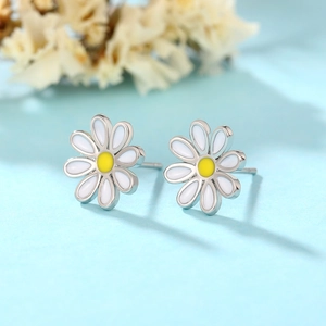 Detailed view of daisy stud earrings with white enamel petals and yellow center detail