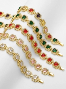 Close-up of multicolored square zircon bracelets with 18k gold plating on white fabric