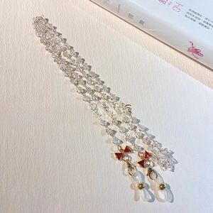 Detail of beaded crystal eyewear chain featuring red mini bows and golden clasps