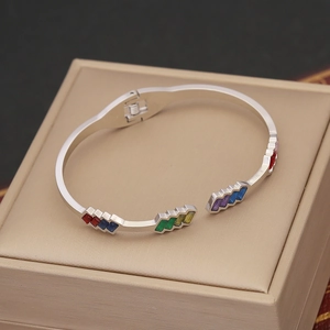 Detailed macro view of silver steel bracelet with colorful enamel geometric inlays on a case