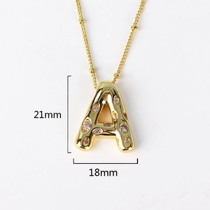 Macro view of gold-plated letter A pendant with cubic zirconia inlay and dimensions
