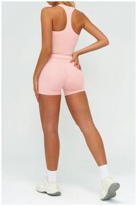 Détail du débardeur de yoga rose clair avec dos nageur et texture de tissu brossé doux