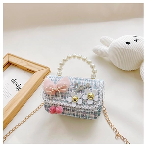 Close-up of girls tweed crossbody bag with pearl handle and bowknot charm detail