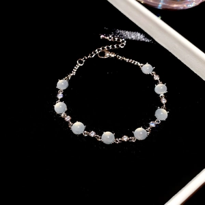 Détail macro du bracelet argenté avec fleurs en zircon et perles d'opale