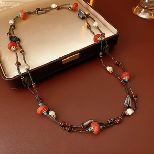 Vue détaillée du collier ethnique multicouche avec perles en bois rouges et coquillages