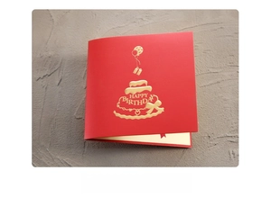 Macro view of red 3D birthday card featuring gold foil stamping on textured paper
