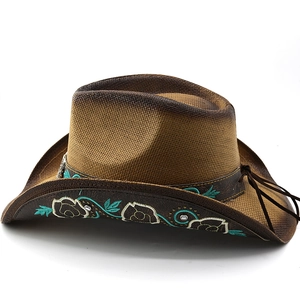 Detail of western straw hat featuring turquoise floral embroidery and metallic rivets