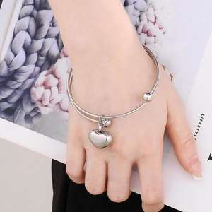 Close-up of a silver hollow heart pendant bracelet on a woman wrist with lifestyle background