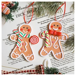 Macro shot of gingerbread man resin ornaments with lollipop and scarf on vintage paper