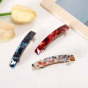 Tre fermagli per capelli in acetato con motivi floreali e marmorizzati blu e marroni