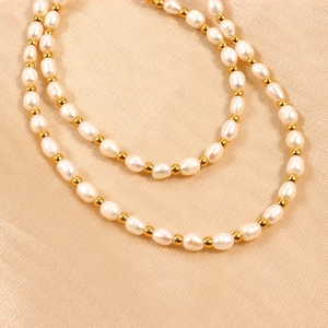 Baroque pearl necklace with gold beads on beige fabric, elegant vintage style jewelry piece