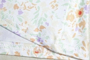 Detailed macro view of floral print fabric with high-quality twin-needle hem stitching