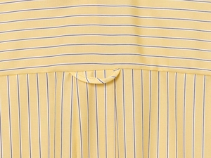 Dettaglio macro della camicia gialla a righe con carré posteriore e passante di sospensione
